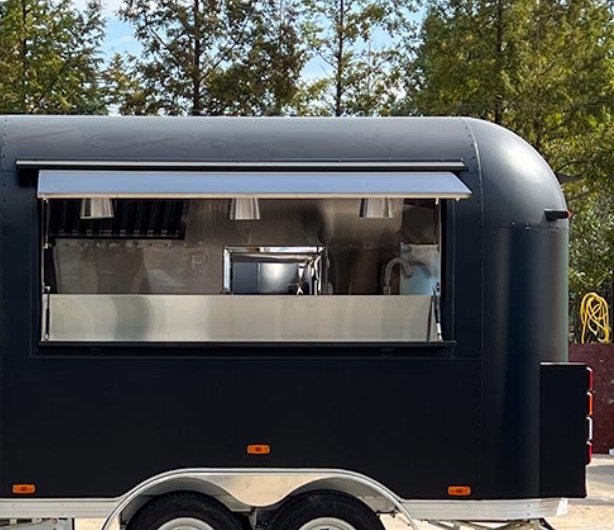 Painted Airstream-style coffee trailer with the service window open